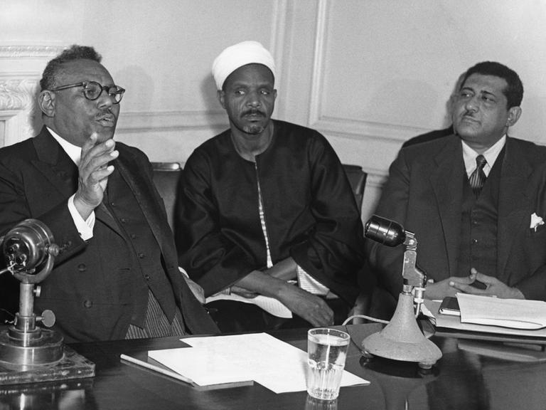 15.11.1954: Sudans erster Premierminister Sayed Ismail El Azhari (links) bei einer Pressekonferenz in London. Neben ihm der sudanesische Justizminister Ali Abd El Rahman und Sozialminister Sayed Yahia Fadly. Bei den Parlamentswahlen 1954 gewannen El…