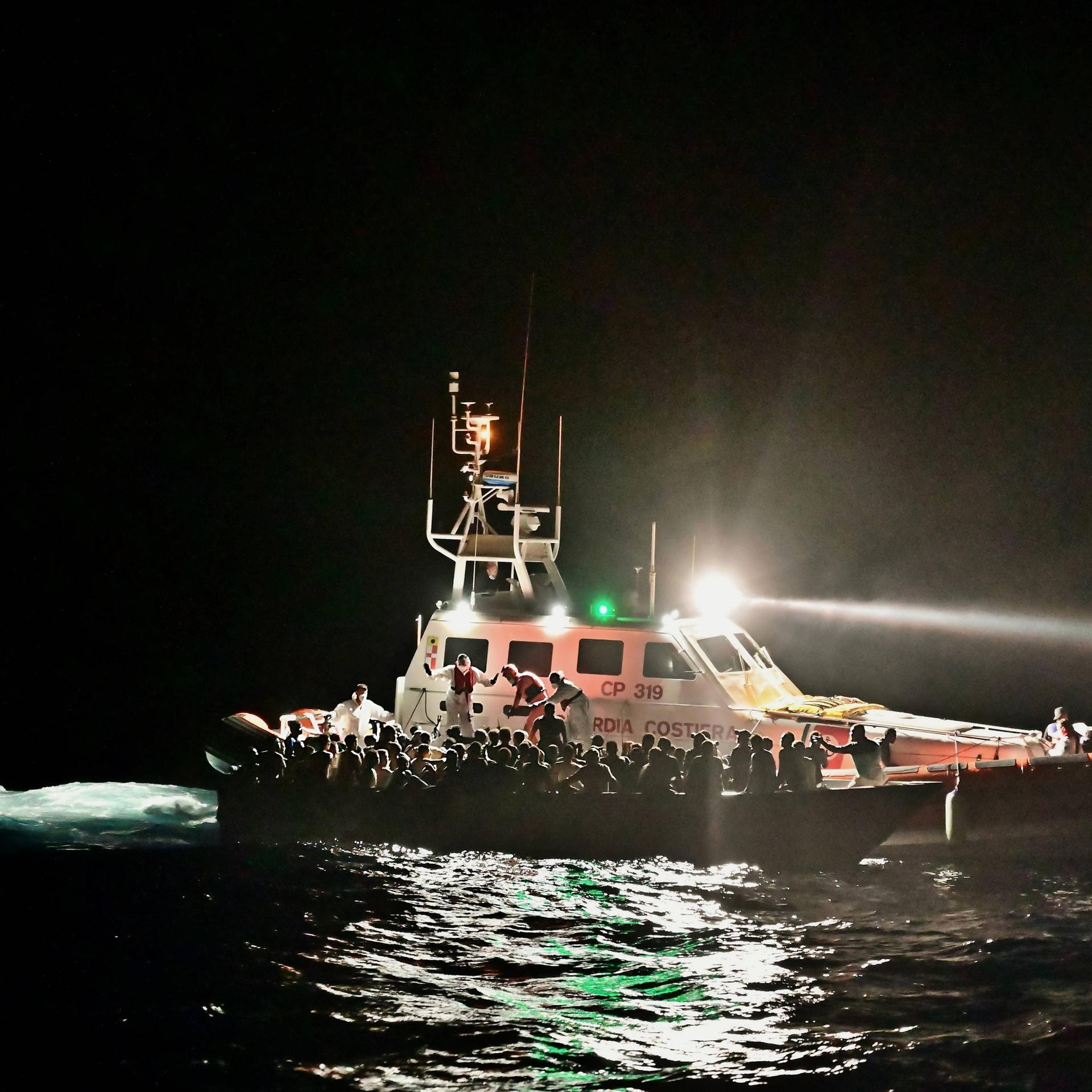 Mittelmeer: Schiffe der Italienischen Küstenwache evakuieren ein Boot mit Flüchtenden