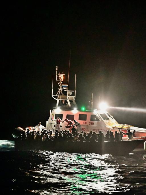 Mittelmeer: Schiffe der Italienischen Küstenwache evakuieren ein Boot mit Flüchtenden Mittelmeer: Schiffe der Italienischen Küstenwache evakuieren ein Boot mit Flüchtenden