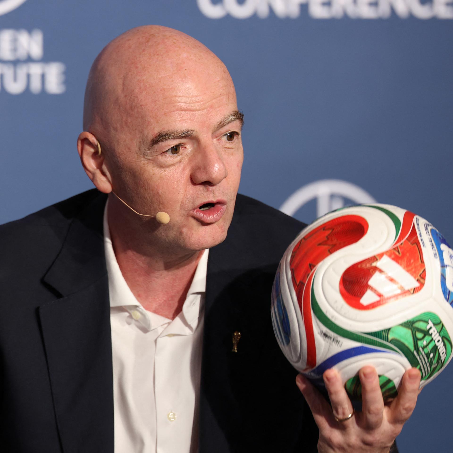 FIFA-Präsident Gianni Infantino hält einen bunten Fußball hoch