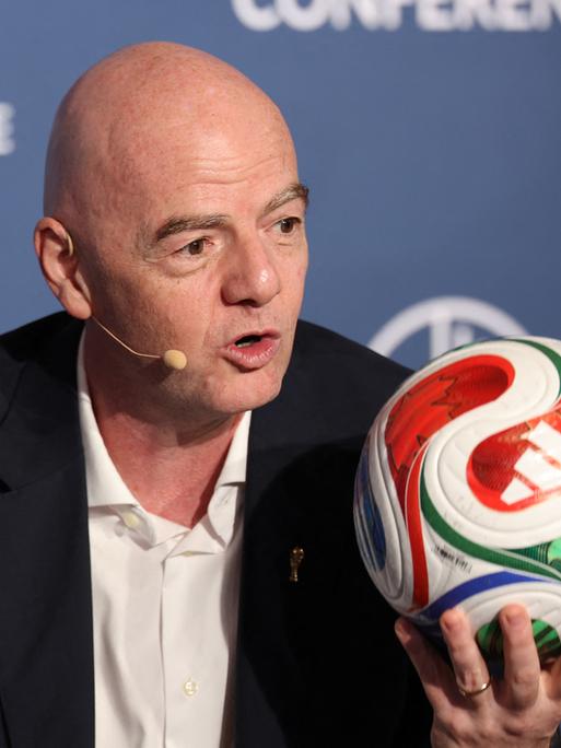 FIFA-Präsident Gianni Infantino hält einen bunten Fußball hoch FIFA-Präsident Gianni Infantino hält einen bunten Fußball hoch