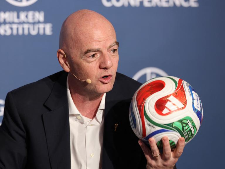 FIFA-Präsident Gianni Infantino hält einen bunten Fußball hoch FIFA-Präsident Gianni Infantino hält einen bunten Fußball hoch