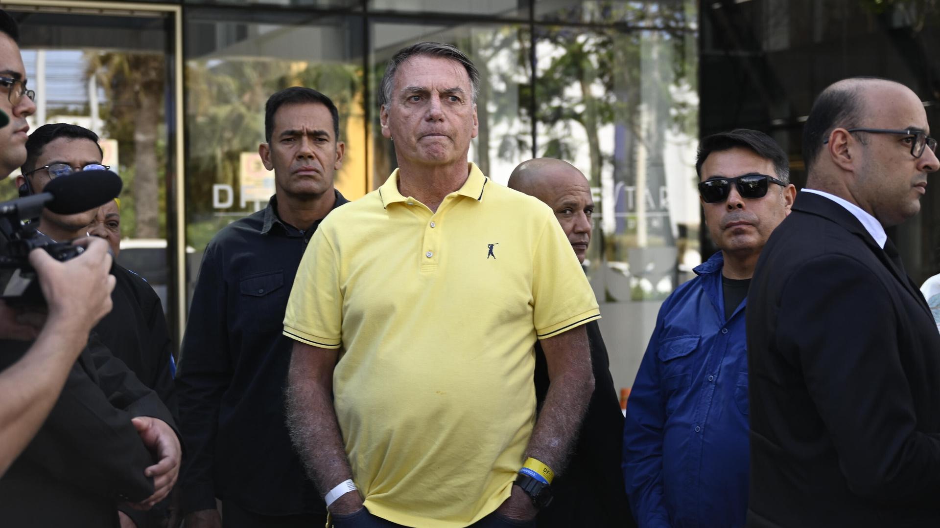 Brasiliens Ex-Präsident Jair Bolsonaro steht in einem gelben Poloshirt vor einem Krankenhaus und wartet. Brasiliens Ex-Präsident Jair Bolsonaro steht in einem gelben Poloshirt vor einem Krankenhaus und wartet.
