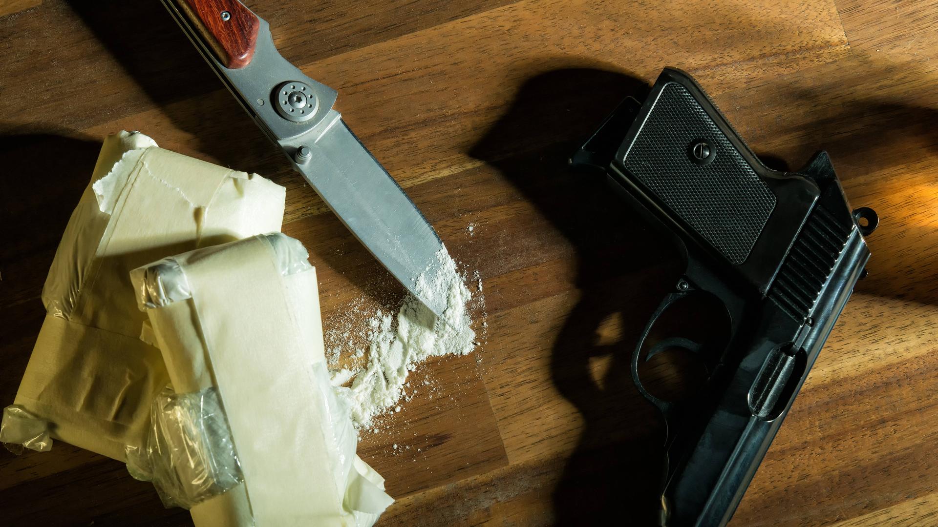 Ein Beutel mit weißem Pulver, ein Messer und eine Pistole