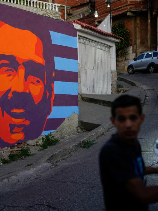 Zwei Mopedfahrer fahren in Caracas an einem Wahlkampf-Mural von Nicolás Maduro vorbei (Venezuela,17.07.2024)