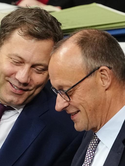 Bundesfinanzminister Lars Klingbeil (SPD) spricht mit Bundeskanzler Friedrich Merz (CDU) während einer Sitzung des Bundestags.