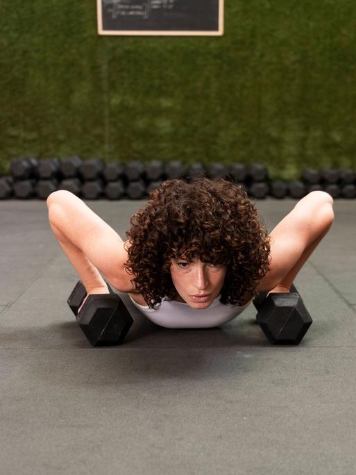 Frau stemmt sich bei Liegestützen hoch