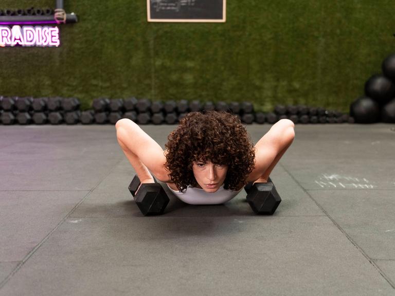 Frau stemmt sich bei Liegestützen hoch