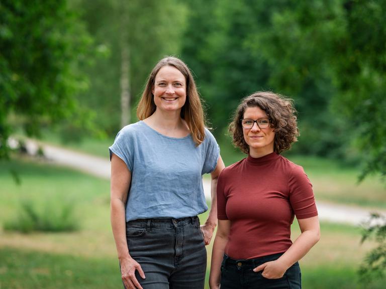 Ann-Kathrin Horn und Ann-Kathrin Büüsker stehen nebeneinander auf einer grünen Wiese, im Hintergrund Bäume