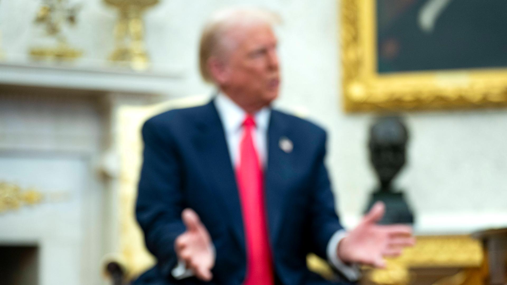 Vergoldeter Untersetzer mit der Aufschrift "45th" und "Trump". Im Hintergrund US-präsident Donald Trump Vergoldeter Untersetzer mit der Aufschrift "45th" und "Trump". Im Hintergrund US-präsident Donald Trump