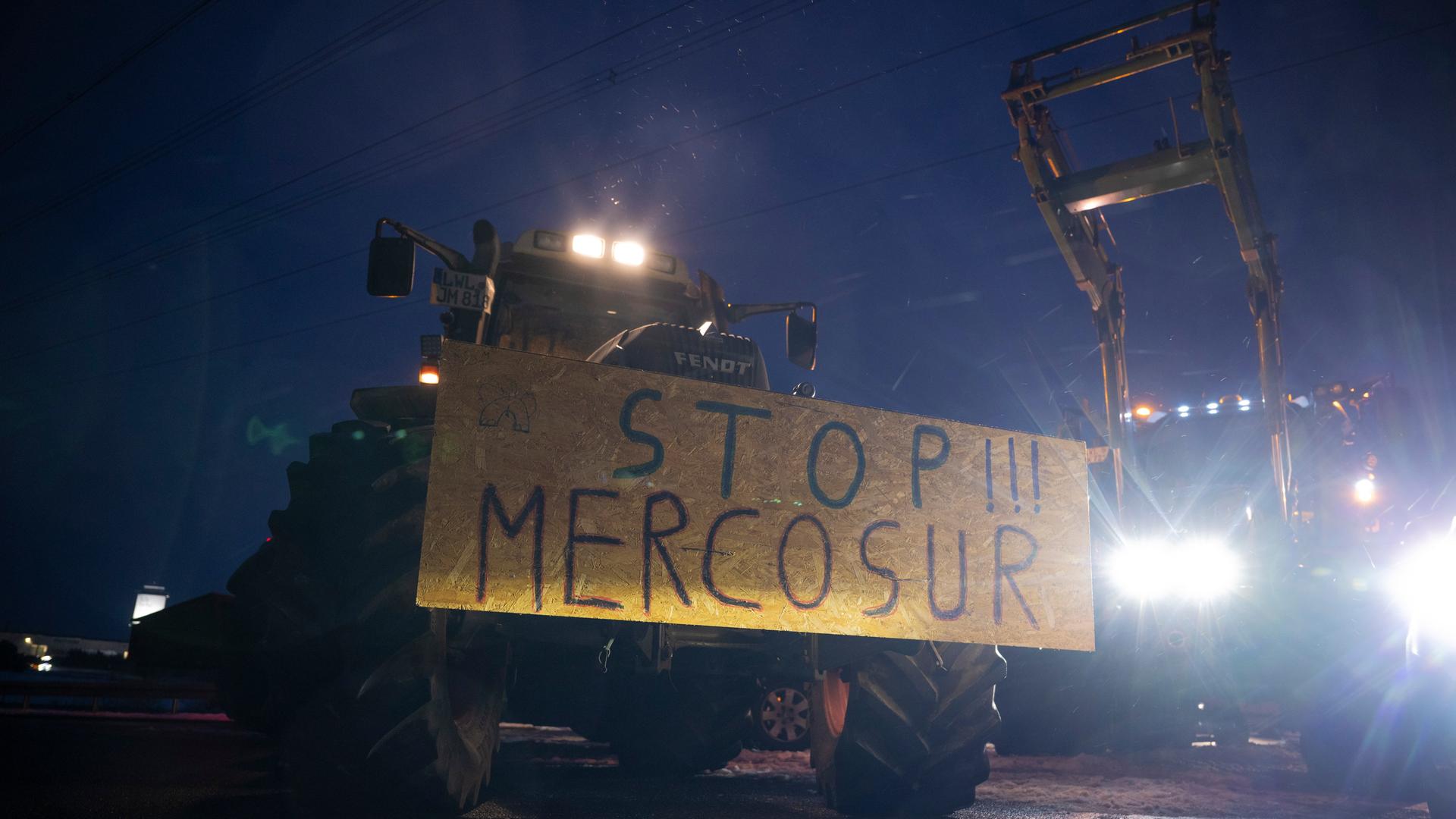 Ein Schild mit der Aufschrift "Stopp!!! Mercosur" ist an einem Traktor befestigt.