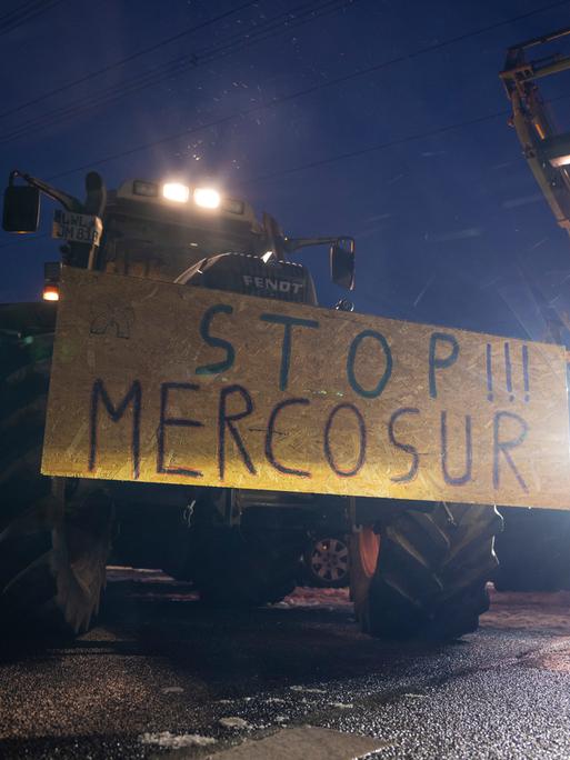 Ein Schild mit der Aufschrift "Stopp!!! Mercosur" ist an einem Traktor befestigt.