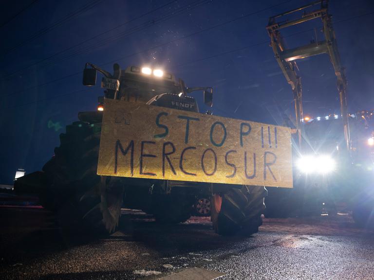 Ein Schild mit der Aufschrift "Stopp!!! Mercosur" ist an einem Traktor befestigt.
