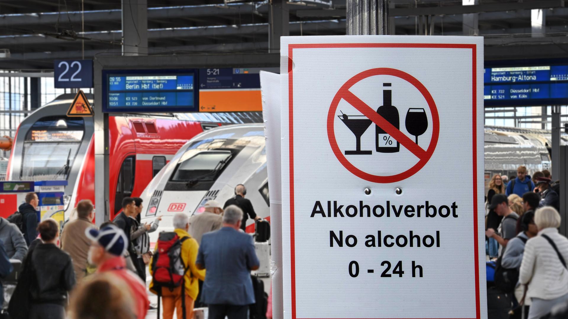 Fotomontage: Menschen in einem Bahnhof, davor ein großes Schild „Alkoholverbot 0-24h“ Fotomontage: Menschen in einem Bahnhof, davor ein großes Schild „Alkoholverbot 0-24h“