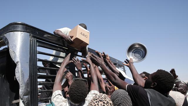Im Sudan versammeln sich Menschen vor einem Lastwagen von humanitären Helfern.