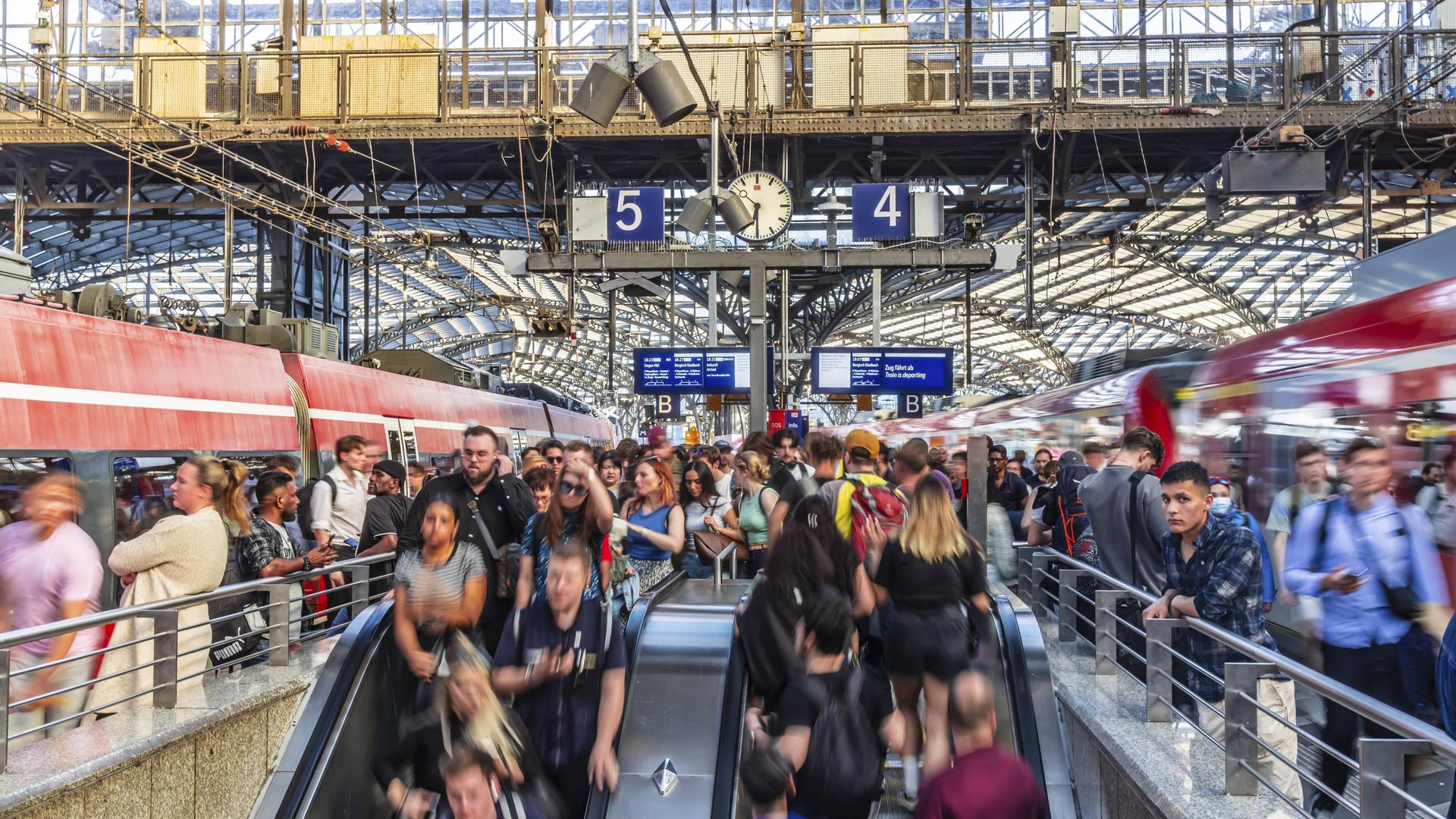 Viele Menschen auf einem Bahnsteig. Manche stehen und warten andere benutzen Rolltreppen. Es sieht voll aus. Viele Menschen auf einem Bahnsteig. Manche stehen und warten andere benutzen Rolltreppen. Es sieht voll aus.