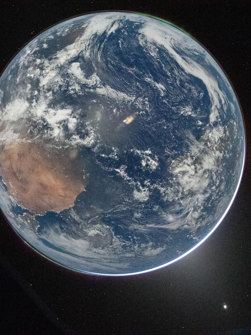 Dieses NASA-Foto zeigt die Erde durch das Fenster des Orion-Raumschiffs. es wurde am 2. April 2026 von NASA-Astronaut Reid Wiseman, Kommandant von Artemis II, nach Abschluss des Translunar-Injektion Manövers fotografiert.