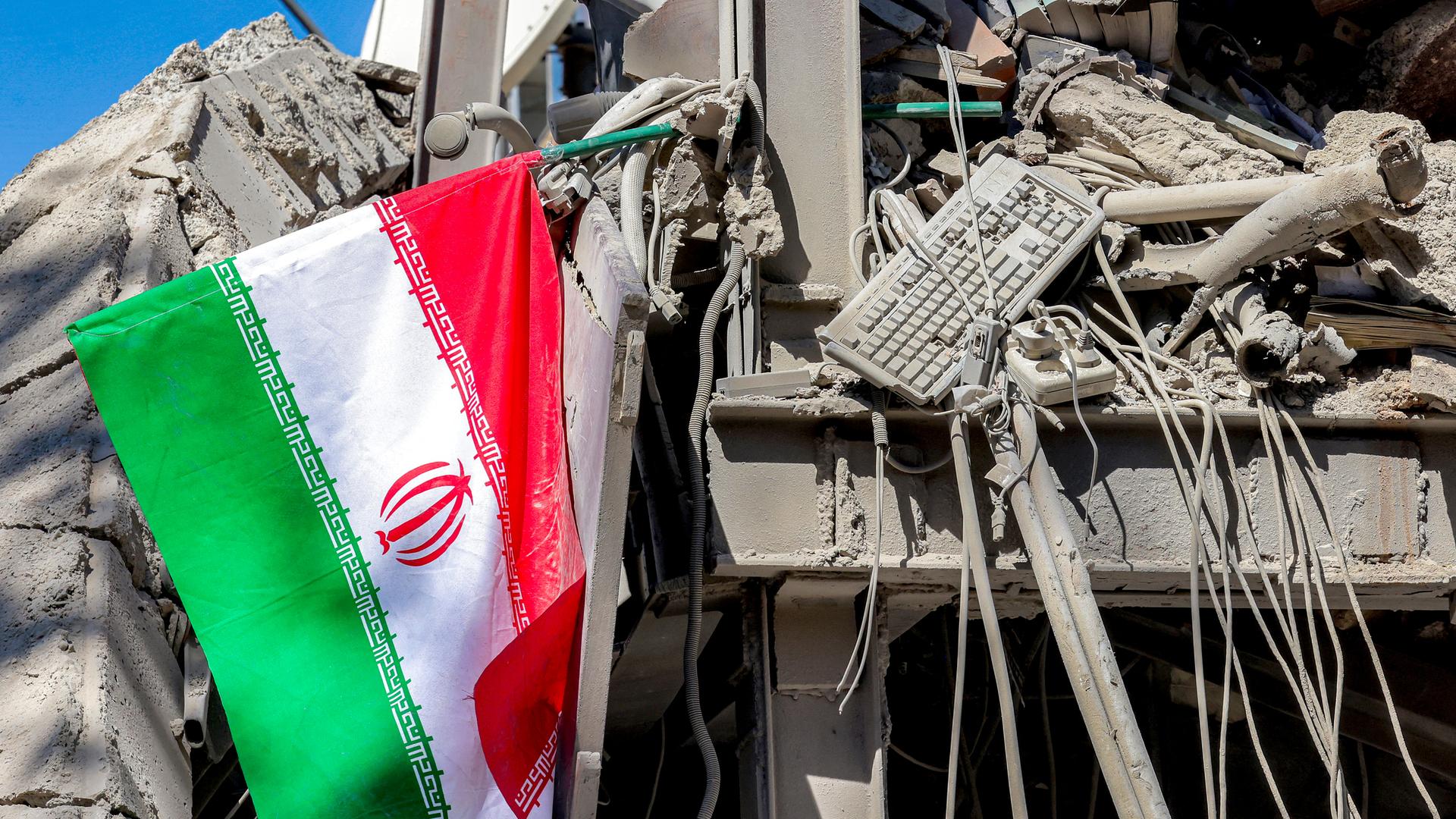 Iranische Flagge liegt neben den Trümmern eines eingestürzten Gebäudes nach den Anschlägen an der Sharif University of Technology in Teheran (Iran, 7.04.2026)