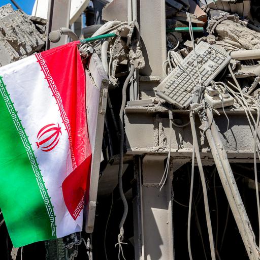 Iranische Flagge liegt neben den Trümmern eines eingestürzten Gebäudes nach den Anschlägen an der Sharif University of Technology in Teheran (Iran, 7.04.2026)