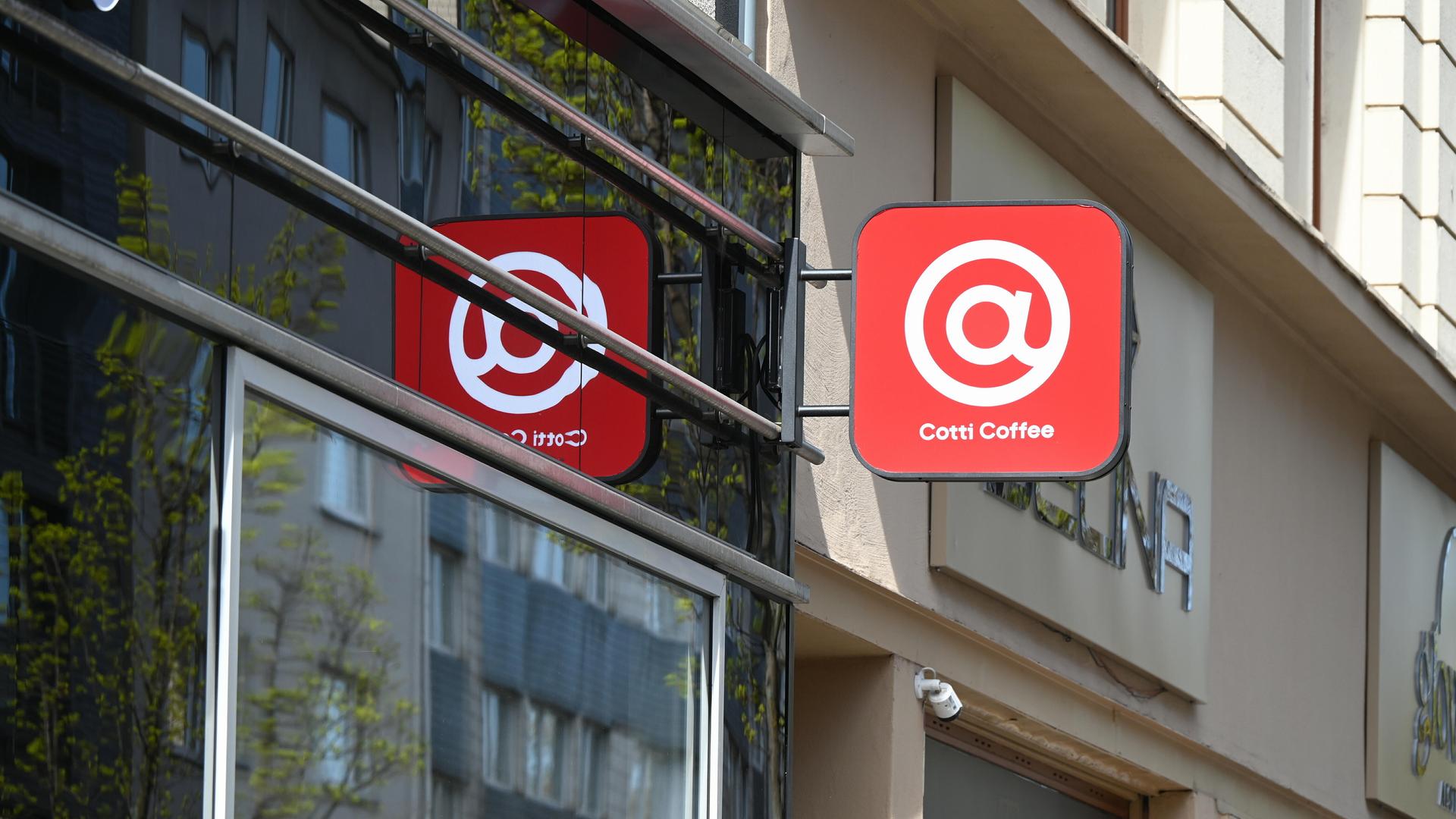 Schild der Kaffeekette Cotti Coffee an einer Hausfassade - ein weißes @-Zeichen auf rotem Grund