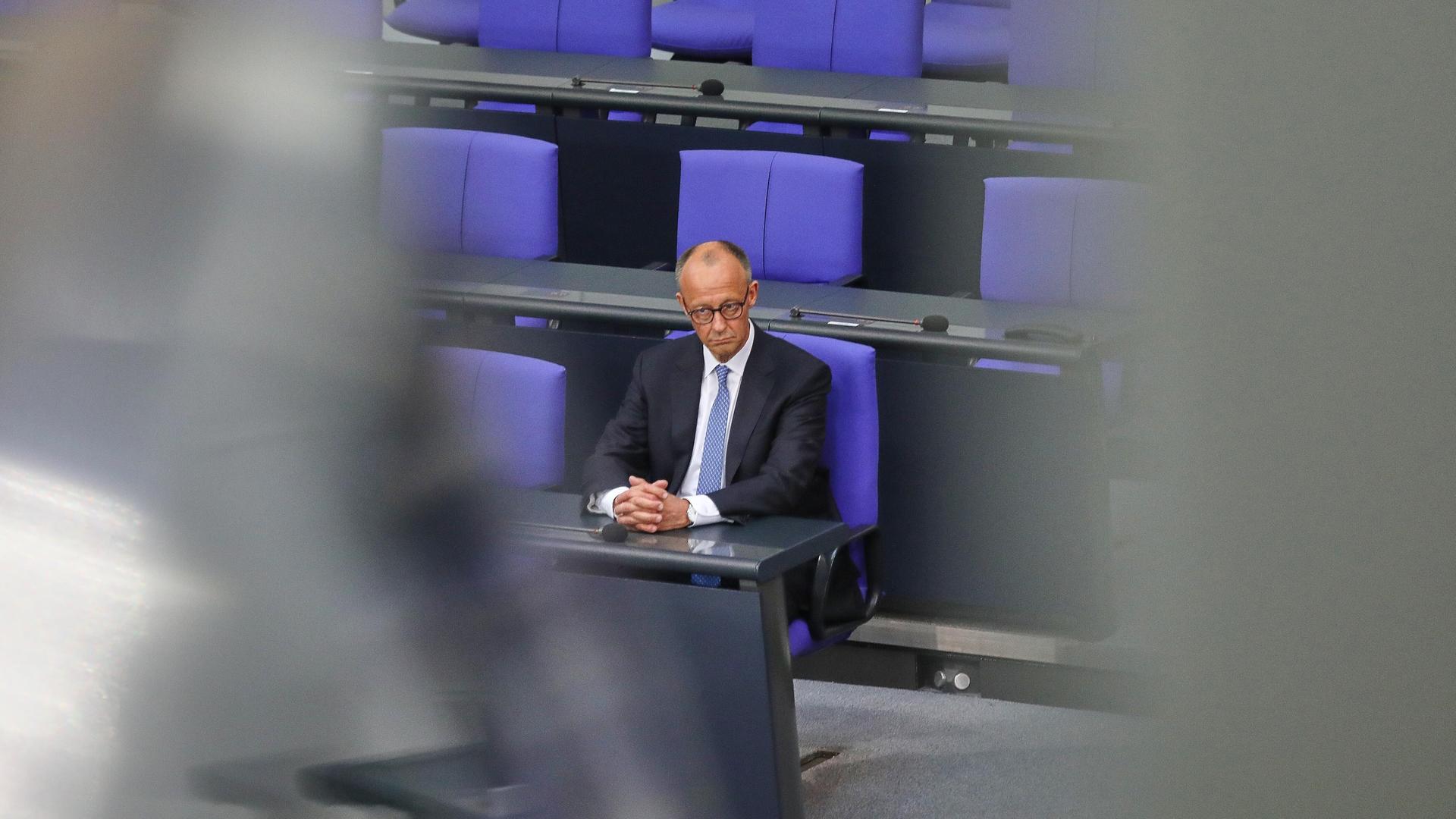 Bundeskanzler Friedrich Merz (CDU) im Bundestag. Er sitzt einsam auf der Regierungsbank.