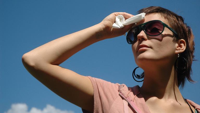Junge schwitzende Frau mit Sonnenbrille. Junge schwitzende Frau mit Sonnenbrille.