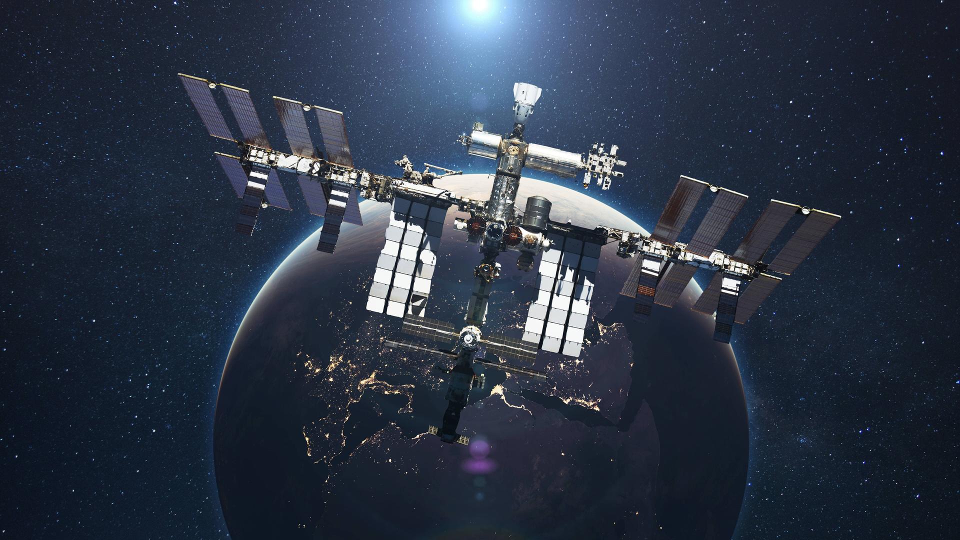 Die ISS fliegt vor dem Hintergrund des blauen Planeten Erde mit dem Licht der Sonne. Die ISS fliegt vor dem Hintergrund des blauen Planeten Erde mit dem Licht der Sonne.