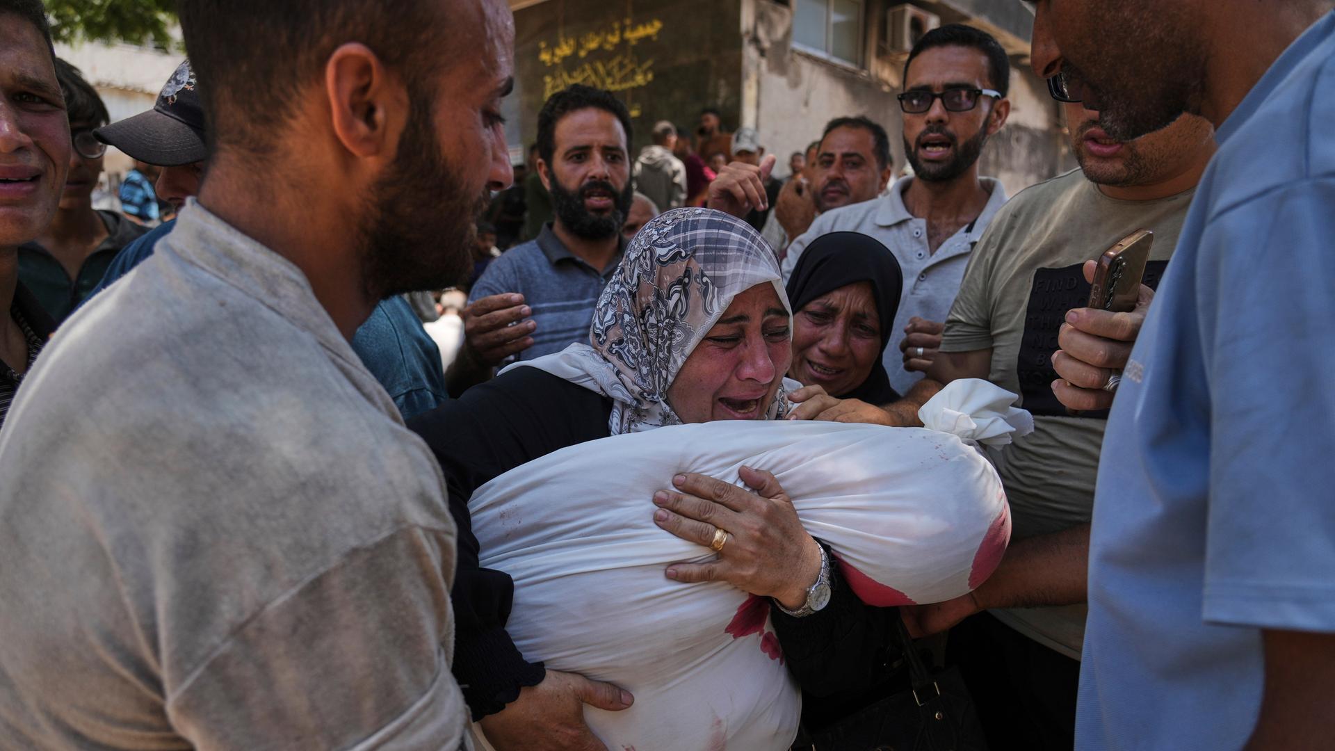 Eine Mutter trauert um ihr Kind im Schifa-Krankenhaus in Gaza-Stadt, viele Menschen sind um sie herum. Eine Mutter trauert um ihr Kind im Schifa-Krankenhaus in Gaza-Stadt, viele Menschen sind um sie herum.