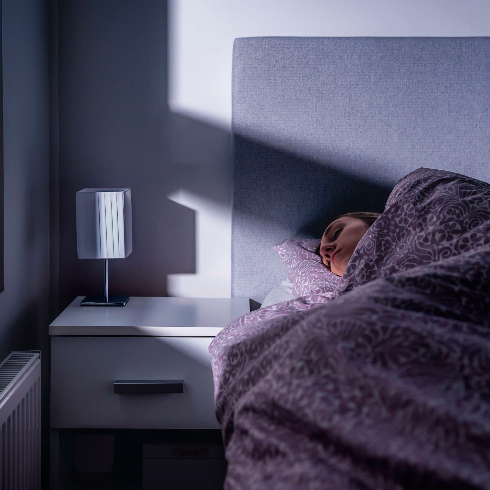 Eine Frau liegt in einem Bett und schläft