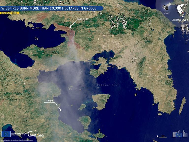 Die Waldbrände nähe Athens in einer Satellitenaufnahme: Es sind Umrisse Griechenlands mit Ausschnitten des Mittelmeers, eine braune Fläche und Rauchschwaden zu erkennen.
