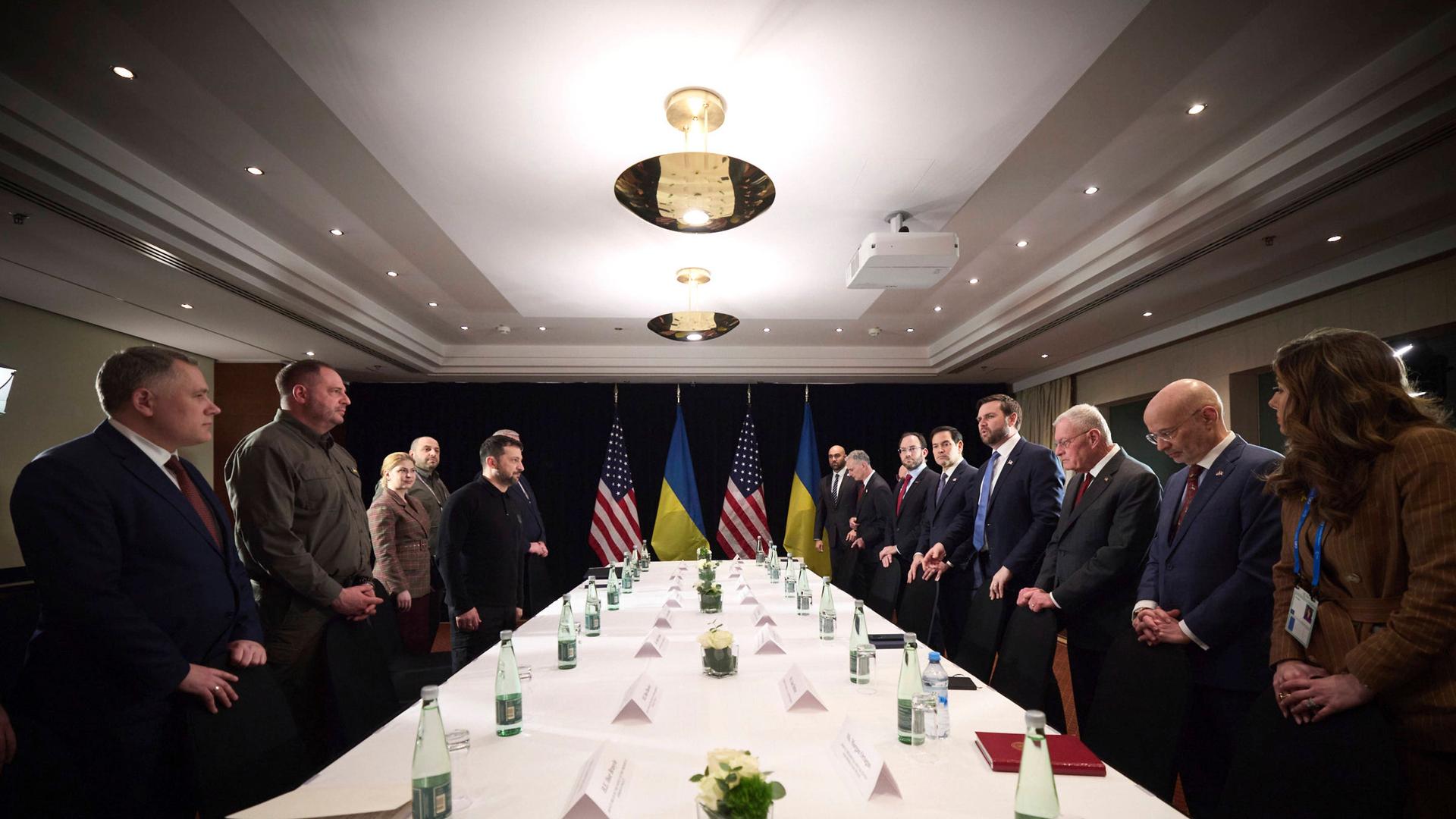 Präsident Selenskyj und US-Vizepräsident JD Vance stehen an einem Tisch mit ukrainischen und amerikanischen Flaggen im Hintergrund. Präsident Selenskyj und US-Vizepräsident JD Vance stehen an einem Tisch mit ukrainischen und amerikanischen Flaggen im Hintergrund.