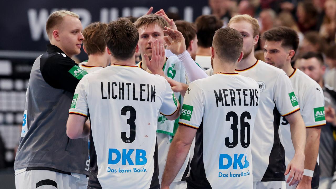 Ein Teil der Handballer der deutschen Nationalmannschaft klatscht sich auf deem Spielfeld ab.