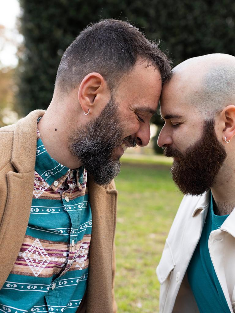Zwei Männer lehnen ihre Köpfe liebevoll gegeneinander. Sie wirken vertraut.