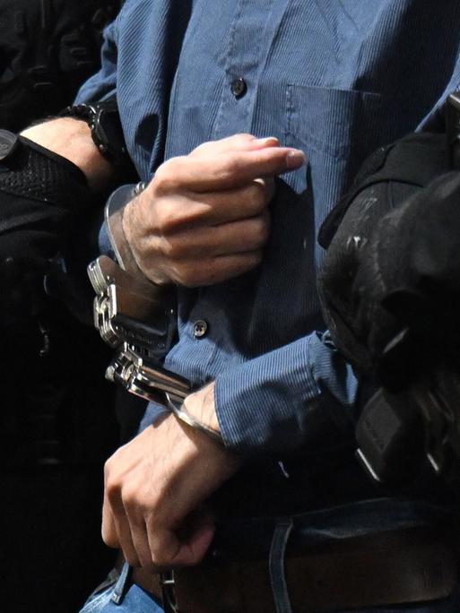 Justizbeamte führen den Täter Taleb A. in Handschellen in den Gerichtssaal. 2024 raste er mit einem Mietwagen auf den Weihnachtsmarkt in Magdeburg. Sechs Menschen sind dabei ums Lebens gekommen. Justizbeamte führen den Täter Taleb A. in Handschellen in den Gerichtssaal. 2024 raste er mit einem Mietwagen auf den Weihnachtsmarkt in Magdeburg. Sechs Menschen sind dabei ums Lebens gekommen.