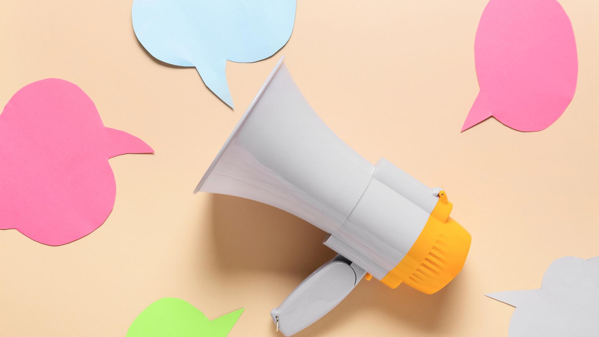 Megaphon und Sprechblasen auf farbigem Hintergrund