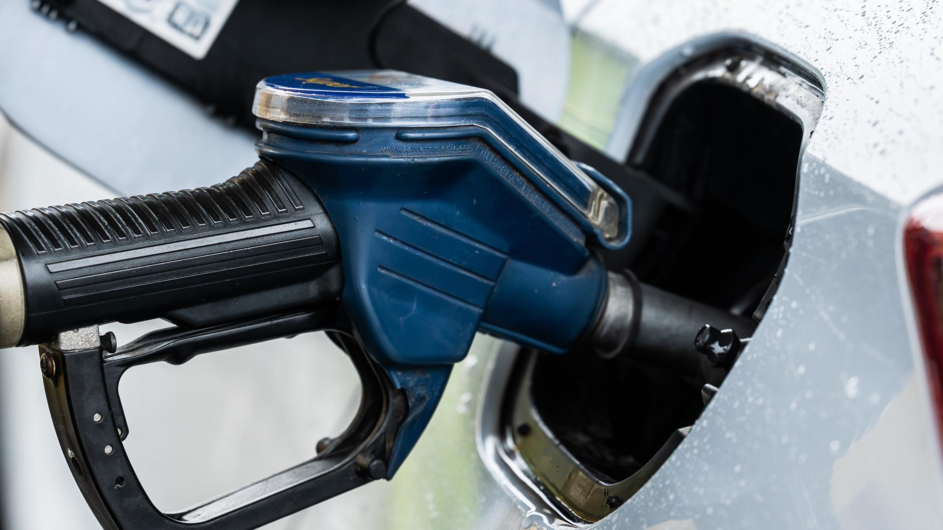 Ein Auto wird an einer Zapfsäule mithilfe eines Tankrüssels an einer Tankstelle betankt. Ein Auto wird an einer Zapfsäule mithilfe eines Tankrüssels an einer Tankstelle betankt.