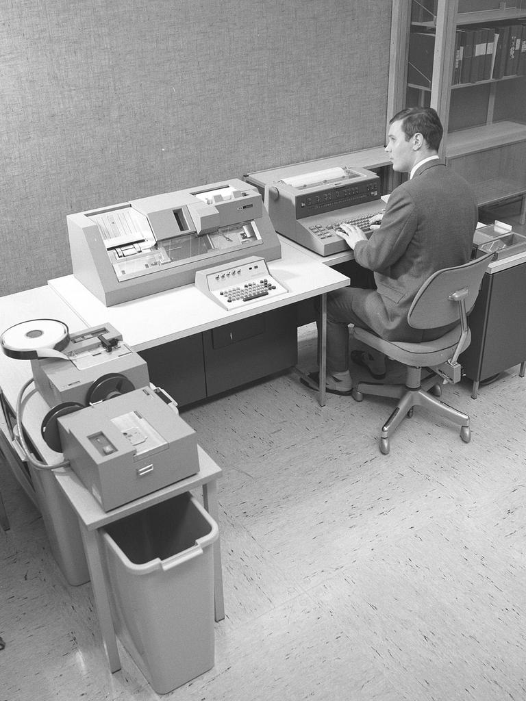 Schwarz-weiß Foto eines Mannes, der in den 1960er Jahren an einem Teil des Computers IBM System 360 arbeitet.