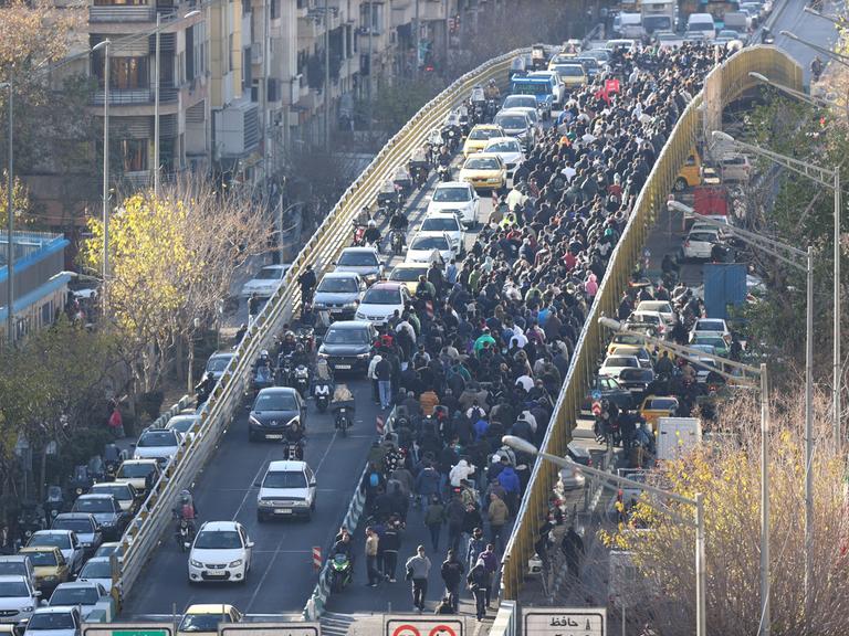 Händler blockieren mit einem Protestmarsch eine normalerweise von Autos befahrene in Teheran. Sie protestieren gegen die schlechte wirtschaftliche Lage und die angeschlagene iranische Währung zu (29.12.2025)