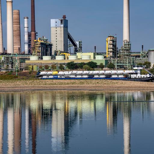 Extremes Niedrigwasser auf dem Rhein führt zur Bildung von Sandbänken. Der Frachter im kann nur mit reduzierter Ladung fahren. Im Hintergrund das Thyssenkrupp Steel Stahlwerk in Duisburg-Marxloh.
