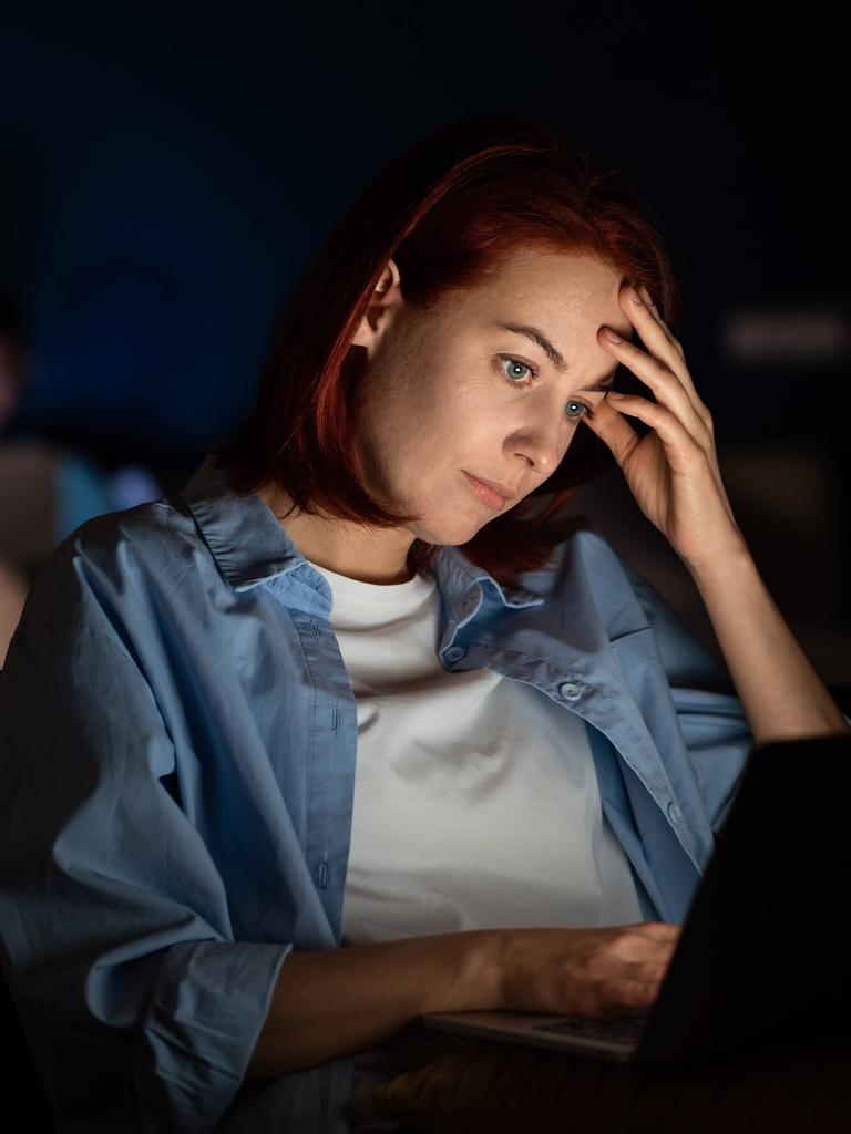 Eine Frau sitzt abends vor dem Laptop Eine Frau sitzt abends vor dem Laptop