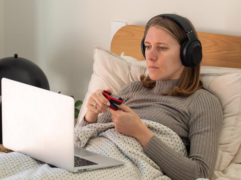 Eine Frau ist krank und konsultiert online einen Arzt