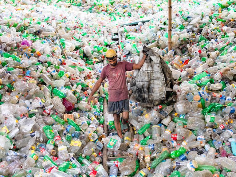 Bangladesch: Ein Mann steht im Plastikmüll Bangladesch: Ein Mann steht im Plastikmüll