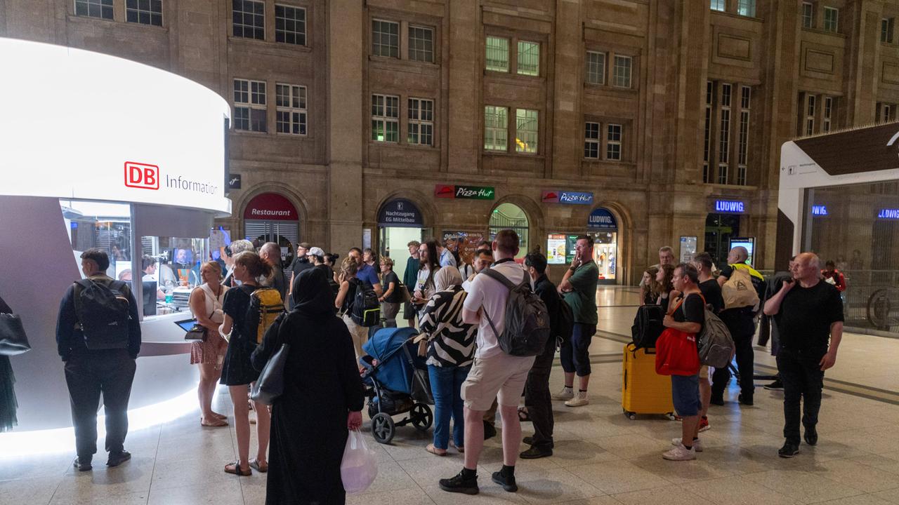 Reisende am 23.06.2026 vor dem DB-Infoschalter am Leipziger Hauptbahnhof. Eine bundesweite Zugfunk-Störung hat den Bahnverkehr lahmgelegt.