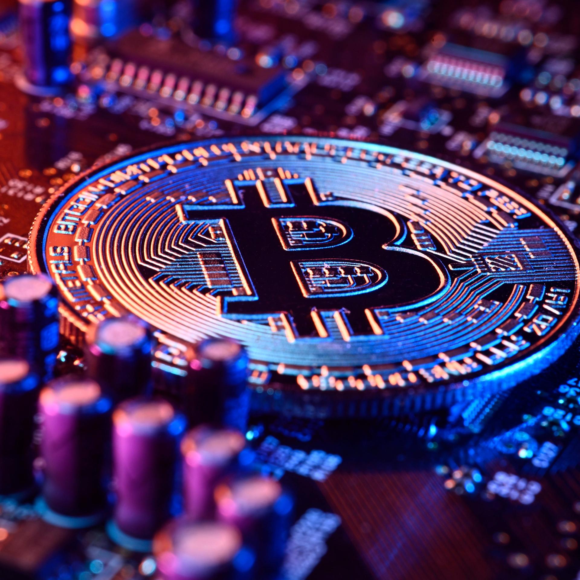 Bitcoin-Münze auf einer Computerplatine