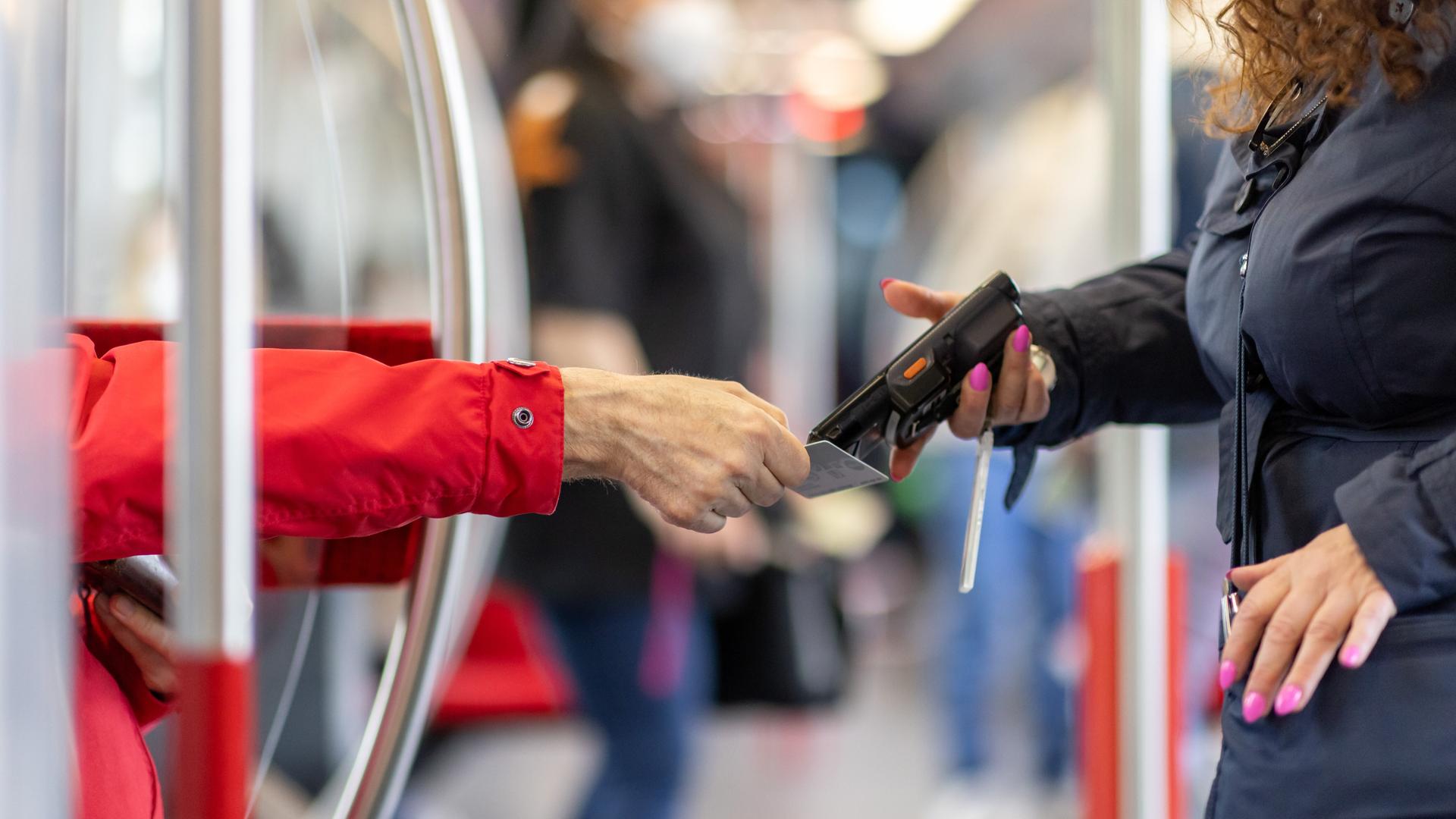 Eine Fahrkartenkontrolleurin kontrolliert in der U-Bahn