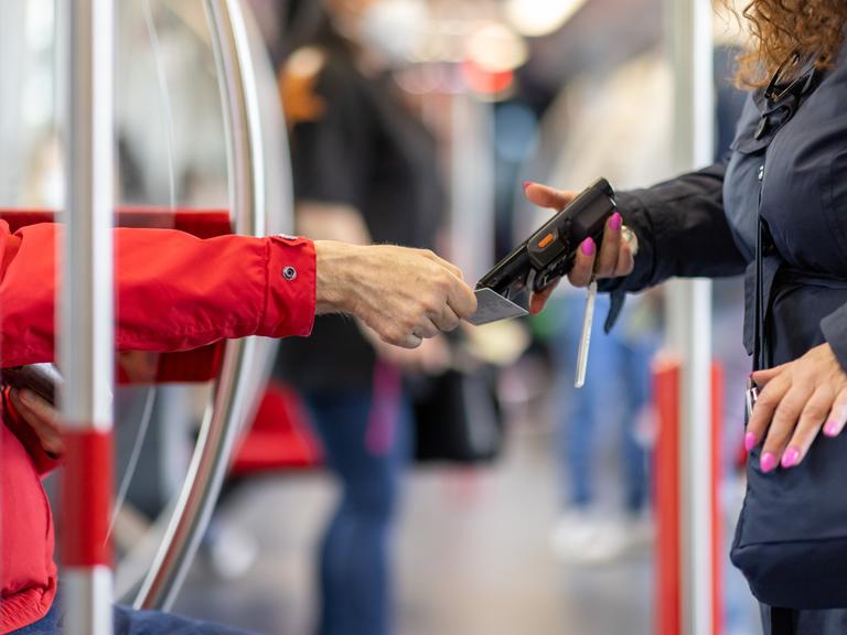 Eine Fahrkartenkontrolleurin kontrolliert in der U-Bahn