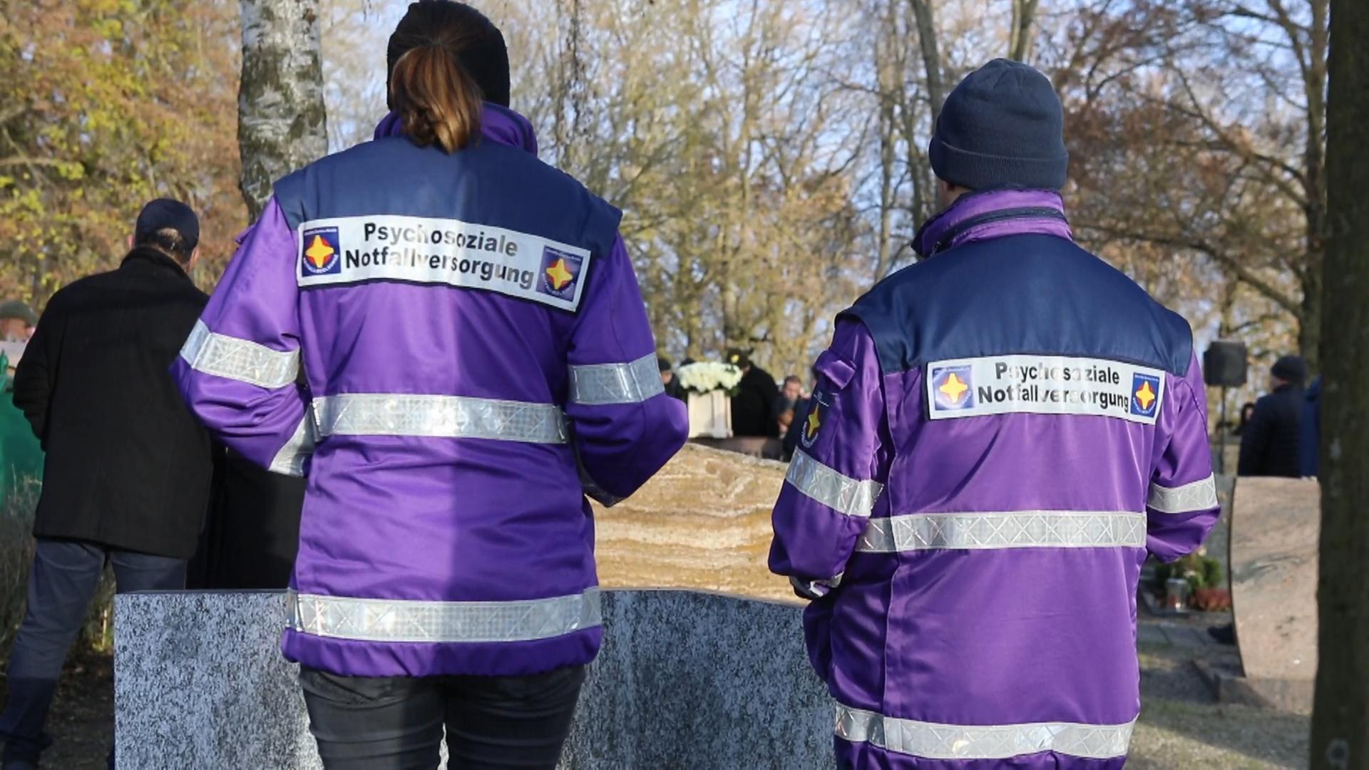 Zwei Notfallseelsorger*innen von hinten Zwei Notfallseelsorger*innen von hinten