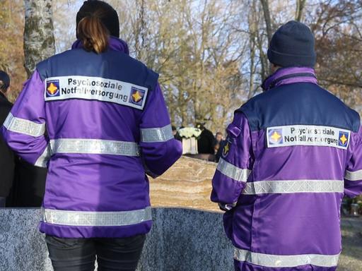 Zwei Notfallseelsorger*innen von hinten Zwei Notfallseelsorger*innen von hinten