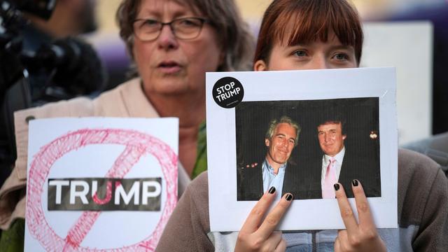 Bei einem Anti-Trump-Protest im englischen Windsor hält eine Frau ein altes Foto hoch, das Donald Trump und Jeffrey Epstein zusammen zeigt. Am Rand des Bildes klebt ein Sticker mit der Aufschrift "Stop Trump".