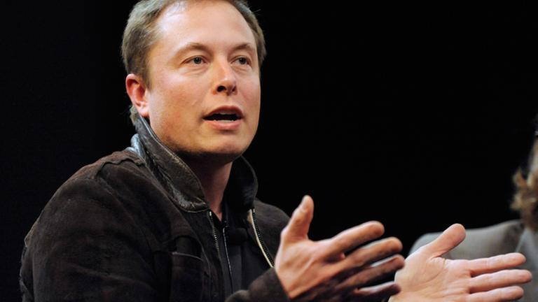Elon Musk gestikuliert und spricht.